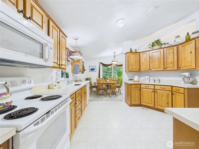 6704 243rd Ave E Unit 96, Buckley, WA 98321 - kitchen with white appliances, vaulted ceiling, light countertops, light floors, and a textured ceiling