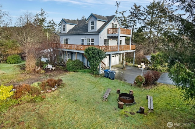 11 Condra Rd, Copalis Beach, WA 98535 - view of front facade with a garage, concrete driveway, a fire pit, a front lawn, and a balcony