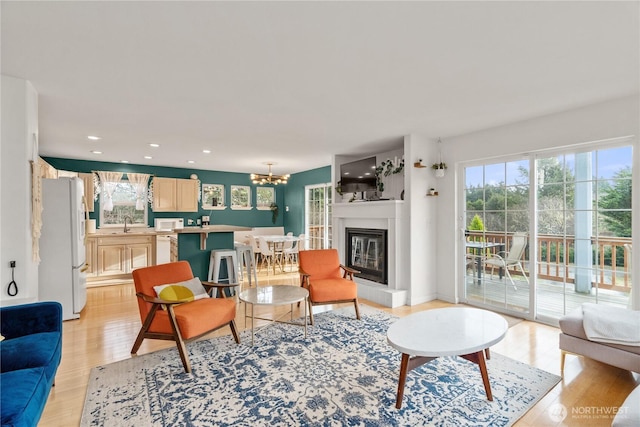 11 Condra Rd, Copalis Beach, WA 98535 - living room with healthy amount of natural light, light wood finished floors, a chandelier, recessed lighting, and a glass covered fireplace