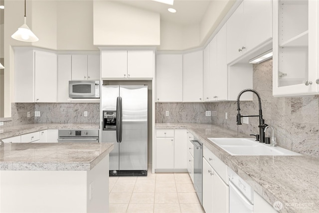 2011 Eldridge Ave, Bellingham, WA 98225 - kitchen with stainless steel appliances, backsplash, white cabinetry, light tile patterned floors, and pendant lighting