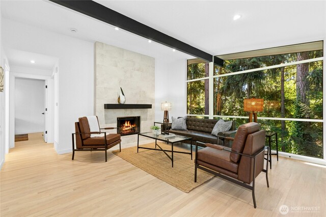 14517 SE 41st Ln, Bellevue, WA 98006 - living room with healthy amount of natural light, expansive windows, wood finished floors, a fireplace, and beamed ceiling
