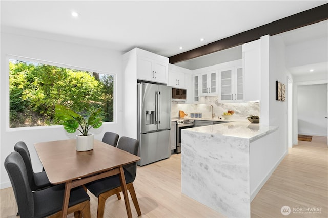 14517 SE 41st Ln, Bellevue, WA 98006 - kitchen with appliances with stainless steel finishes, decorative backsplash, a peninsula, glass insert cabinets, and white cabinetry