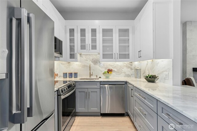 14517 SE 41st Ln, Bellevue, WA 98006 - kitchen with appliances with stainless steel finishes, gray cabinets, light stone counters, and backsplash
