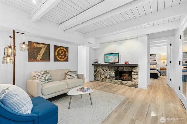 14517 SE 41st Ln, Bellevue, WA 98006 - living area with light wood finished floors, a stone fireplace, and a wooden ceiling with exposed beams