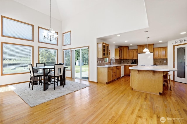 4024RD E Caldwell, Edgewood, WA 98372 - dining room featuring light wood-style floors, a chandelier, a towering ceiling, and recessed lighting