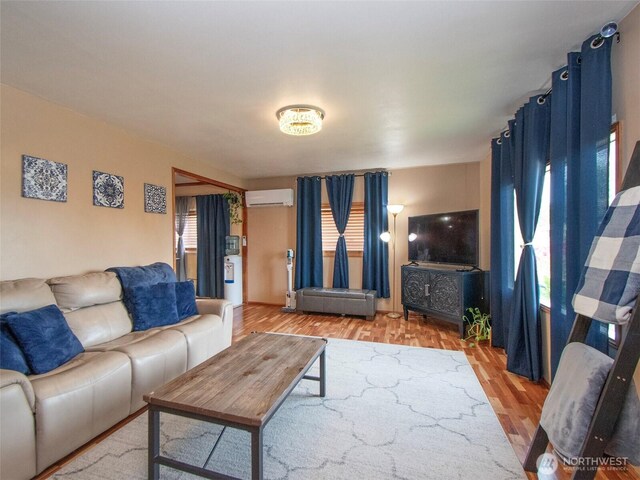 136 W 13th St, Port Angeles, WA 98362 - living room featuring an AC wall unit and light wood-type flooring