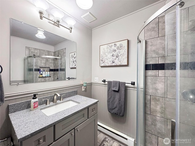 136 W 13th St, Port Angeles, WA 98362 - full bath with baseboard heating, a shower stall, vanity, and wainscoting
