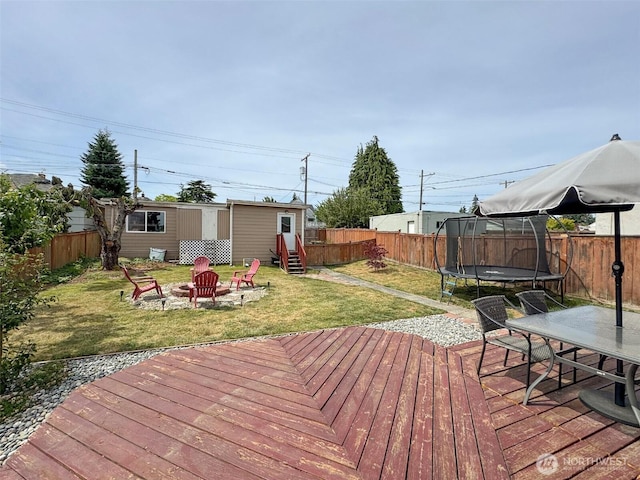 136 W 13th St, Port Angeles, WA 98362 - wooden deck with a trampoline, an outdoor fire pit, a fenced backyard, and an outdoor structure