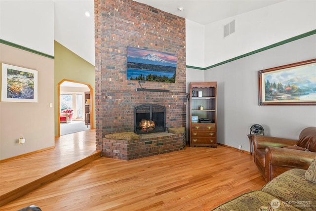 405 S Waugh Rd, Mount Vernon, WA 98274 - living room featuring a high ceiling, wood finished floors, a fireplace, and arched walkways