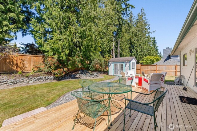 405 S Waugh Rd, Mount Vernon, WA 98274 - wooden terrace featuring a fenced backyard, an outdoor structure, french doors, and outdoor dining area