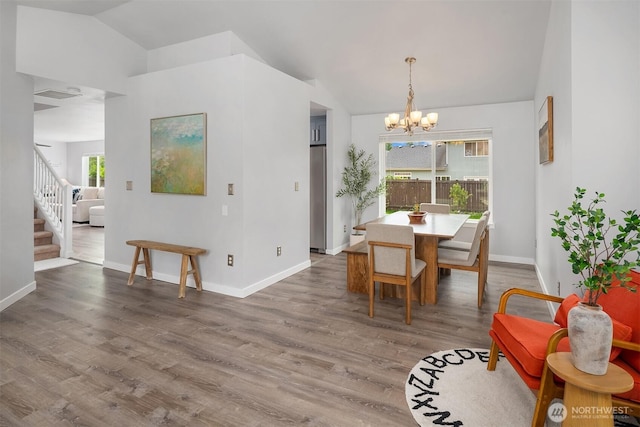 23619 SE 245th St, Maple Valley, WA 98038 - dining space with lofted ceiling, a chandelier, stairway, and wood finished floors