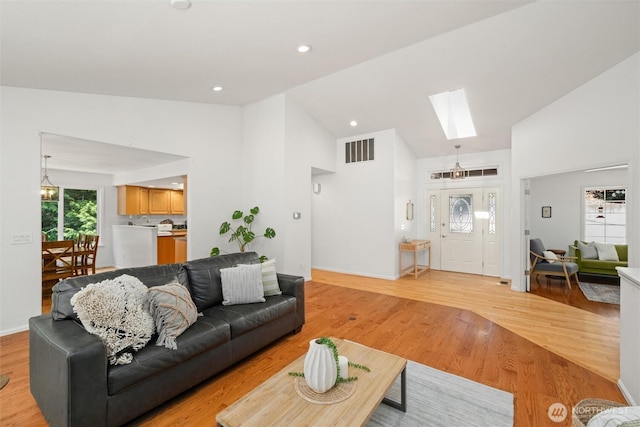 3204 30th St, Bellingham, WA 98225 - living room featuring a skylight, light wood-style flooring, and high vaulted ceiling