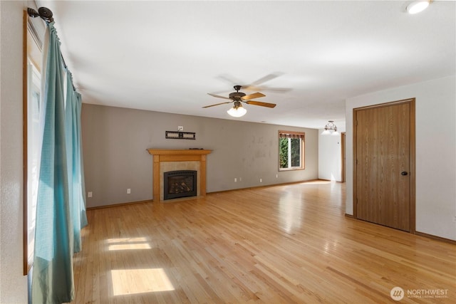 7511 Kittiwake Dr SE, Olympia, WA 98513 - unfurnished living room featuring light wood-style floors, ceiling fan, and a fireplace