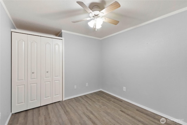 7511 Kittiwake Dr SE, Olympia, WA 98513 - unfurnished bedroom featuring wood finished floors, a closet, crown molding, and ceiling fan
