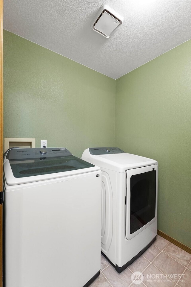 7511 Kittiwake Dr SE, Olympia, WA 98513 - laundry room with independent washer and dryer, a textured ceiling, and light tile patterned floors
