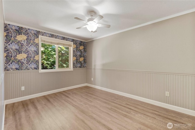 7511 Kittiwake Dr SE, Olympia, WA 98513 - spare room featuring wood finished floors, crown molding, ceiling fan, and wainscoting