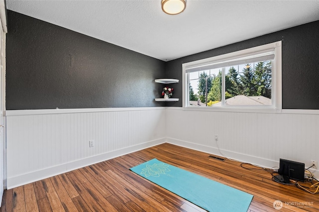 14618 SE 275th Pl, Kent, WA 98042 - workout room with wainscoting, wood-type flooring, and a textured wall