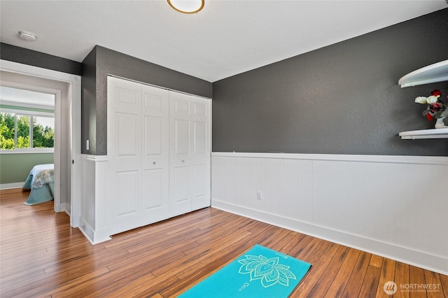 14618 SE 275th Pl, Kent, WA 98042 - unfurnished bedroom featuring wainscoting, hardwood / wood-style floors, a closet, and a textured wall