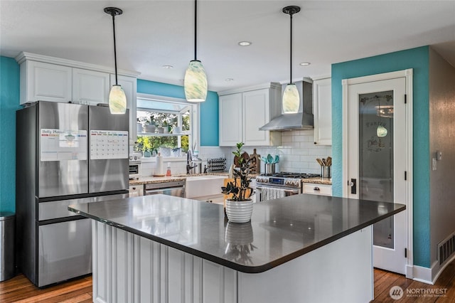 14618 SE 275th Pl, Kent, WA 98042 - kitchen featuring wall chimney exhaust hood, appliances with stainless steel finishes, wood finished floors, decorative backsplash, and white cabinets