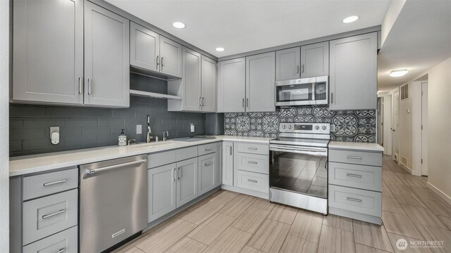 11021 Glen Acres Dr S Unit B, Seattle, WA 98168 - kitchen with stainless steel appliances, gray cabinets, light countertops, decorative backsplash, and recessed lighting