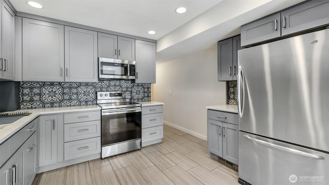 11021 Glen Acres Dr S Unit B, Seattle, WA 98168 - kitchen with appliances with stainless steel finishes, gray cabinets, light countertops, backsplash, and recessed lighting