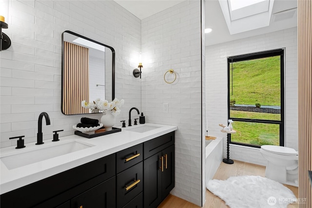 9320 Hoeder Ln, Bothell, WA 98011 - full bath with a skylight, wood finished floors, double vanity, plenty of natural light, and tile walls