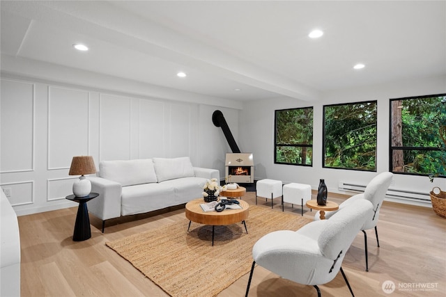 9320 Hoeder Ln, Bothell, WA 98011 - living area featuring a decorative wall, a wood stove, light wood-style flooring, recessed lighting, and beam ceiling