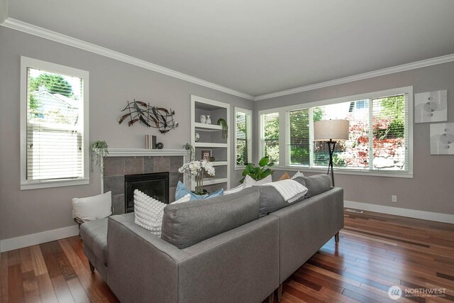 12530 68th Ave SE, Snohomish, WA 98296 - living area with hardwood / wood-style floors, crown molding, a tiled fireplace, and built in shelves