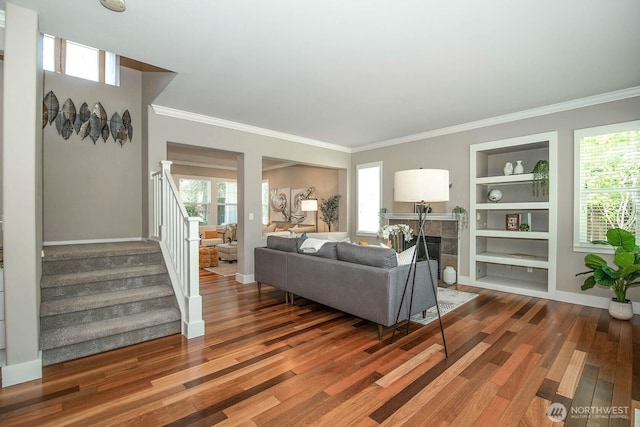 12530 68th Ave SE, Snohomish, WA 98296 - living area featuring wood finished floors, built in shelves, stairs, ornamental molding, and a tiled fireplace