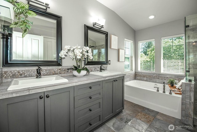 12530 68th Ave SE, Snohomish, WA 98296 - bathroom with a bath, double vanity, stone finish floors, vaulted ceiling, and tiled shower