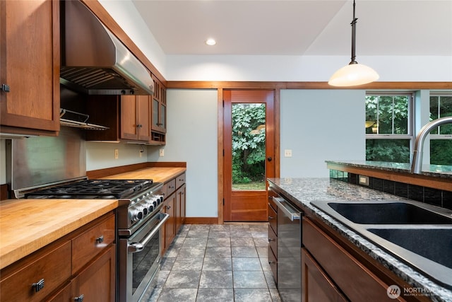 14450 Austin Pl, Anacortes, WA 98221 - kitchen with appliances with stainless steel finishes, under cabinet range hood, wooden counters, decorative light fixtures, and brown cabinetry