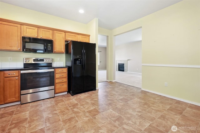 5723 66th Ave SE, Lacey, WA 98513 - kitchen featuring black appliances, dark countertops, recessed lighting, a tiled fireplace, and brown cabinetry