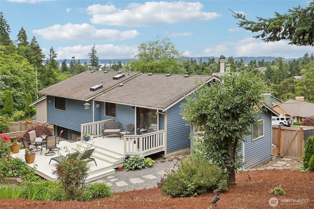 1435 S 263rd Pl, Des Moines, WA 98198 - back of house featuring a wooden deck, a shingled roof, a chimney, and a patio
