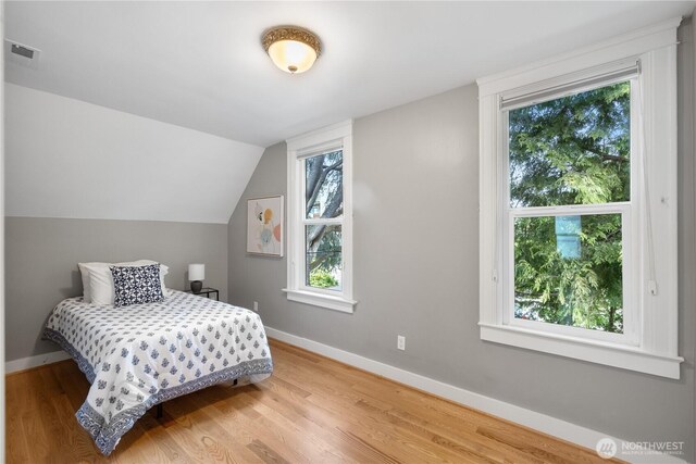 1531 NW 62nd St, Seattle, WA 98107 - bedroom featuring wood finished floors, multiple windows, and vaulted ceiling