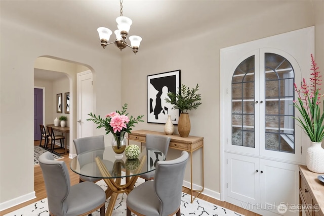 239 S 58th St, Tacoma, WA 98408 - dining space featuring arched walkways, a chandelier, and light wood finished floors