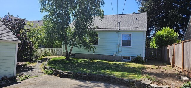 239 S 58th St, Tacoma, WA 98408 - rear view of house featuring roof with shingles, a fenced backyard, and a patio area