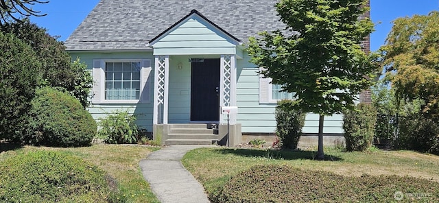 239 S 58th St, Tacoma, WA 98408 - bungalow-style home featuring roof with shingles and a front lawn