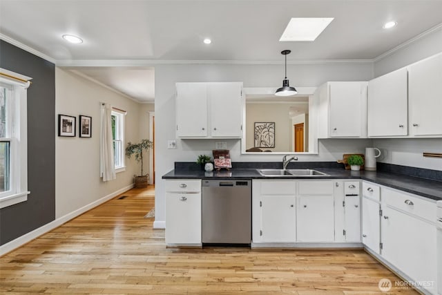 13257 4th Ave S, Burien, WA 98168 - kitchen featuring stainless steel dishwasher, a skylight, dark countertops, crown molding, and white cabinetry
