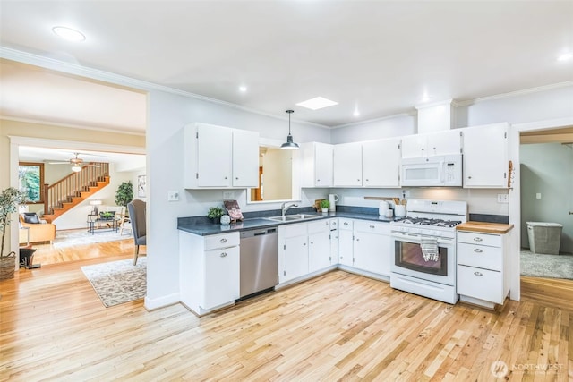13257 4th Ave S, Burien, WA 98168 - kitchen featuring white appliances, white cabinetry, light wood-type flooring, crown molding, and dark countertops