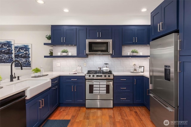 7549 SE 29th St Unit 305, Mercer Island, WA 98040 - kitchen with stainless steel appliances, open shelves, blue cabinetry, and recessed lighting