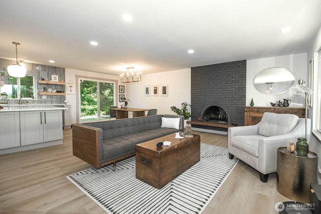 13512 106th Dr SE, Snohomish, WA 98296 - living room with a chandelier, a brick fireplace, light wood-style flooring, and recessed lighting