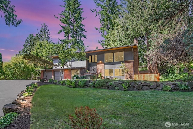 13512 106th Dr SE, Snohomish, WA 98296 - contemporary home featuring brick siding, a sunroom, driveway, a front yard, and an attached garage