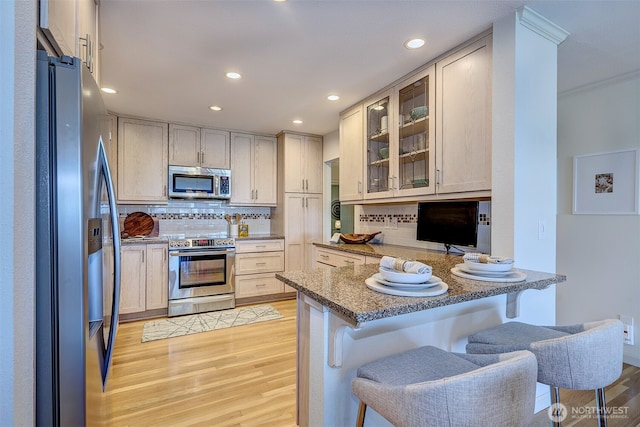 524 Maple St Unit 105, Edmonds, WA 98020 - kitchen featuring stainless steel appliances, a peninsula, light wood-style floors, tasteful backsplash, and recessed lighting
