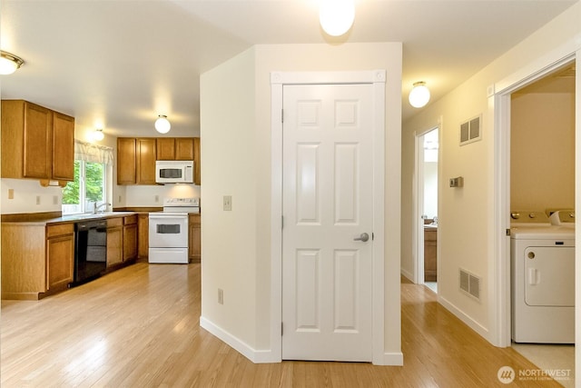 14626 58th Dr SE, Everett, WA 98208 - kitchen with white appliances, brown cabinetry, light wood-style flooring, and washing machine and dryer