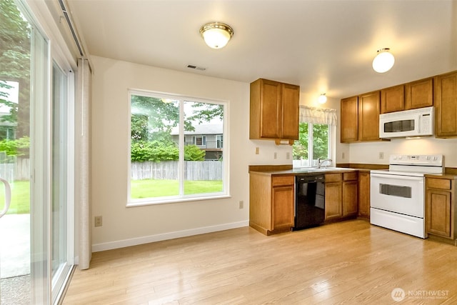 14626 58th Dr SE, Everett, WA 98208 - kitchen featuring white appliances, brown cabinets, and light wood-type flooring