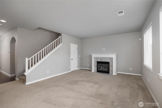535 Beechwood Ct SW, Olympia, WA 98502 - unfurnished living room with stairway, carpet flooring, a tiled fireplace, and arched walkways