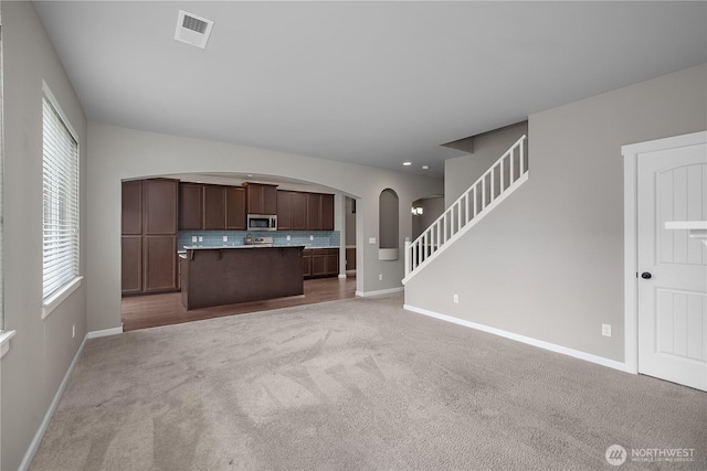 535 Beechwood Ct SW, Olympia, WA 98502 - kitchen featuring stainless steel microwave, arched walkways, open floor plan, and carpet