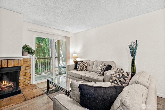 33011 18th Pl S Unit F205, Federal Way, WA 98003 - living area with wood finished floors, a fireplace, and a textured ceiling