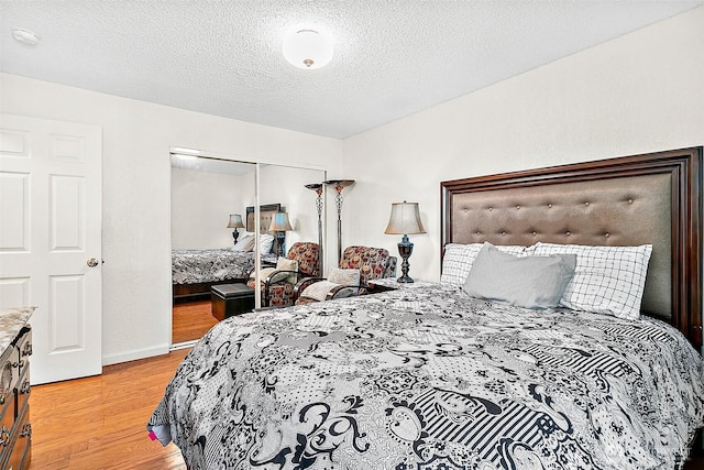 33011 18th Pl S Unit F205, Federal Way, WA 98003 - bedroom with light wood-type flooring, a closet, and a textured ceiling