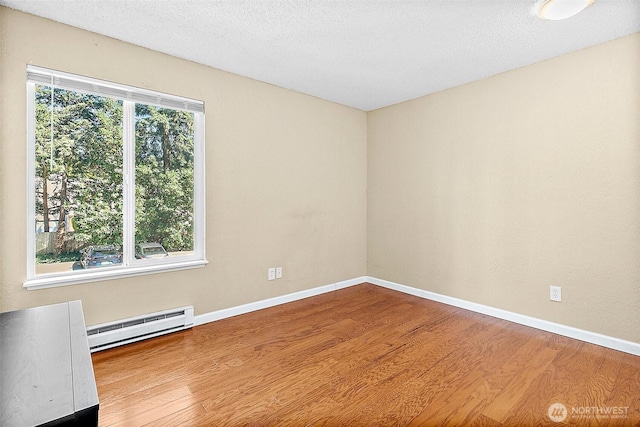 33011 18th Pl S Unit F205, Federal Way, WA 98003 - unfurnished room featuring a baseboard heating unit and wood finished floors